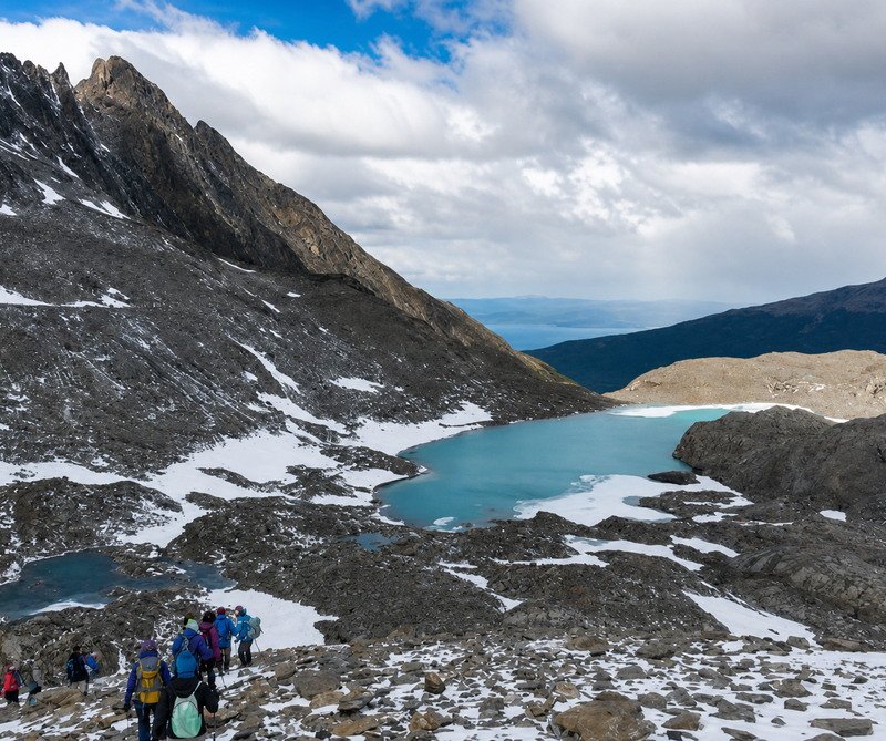 Laguna glaciar y grupo de trekkers camino al Glaciar Vinciguerra